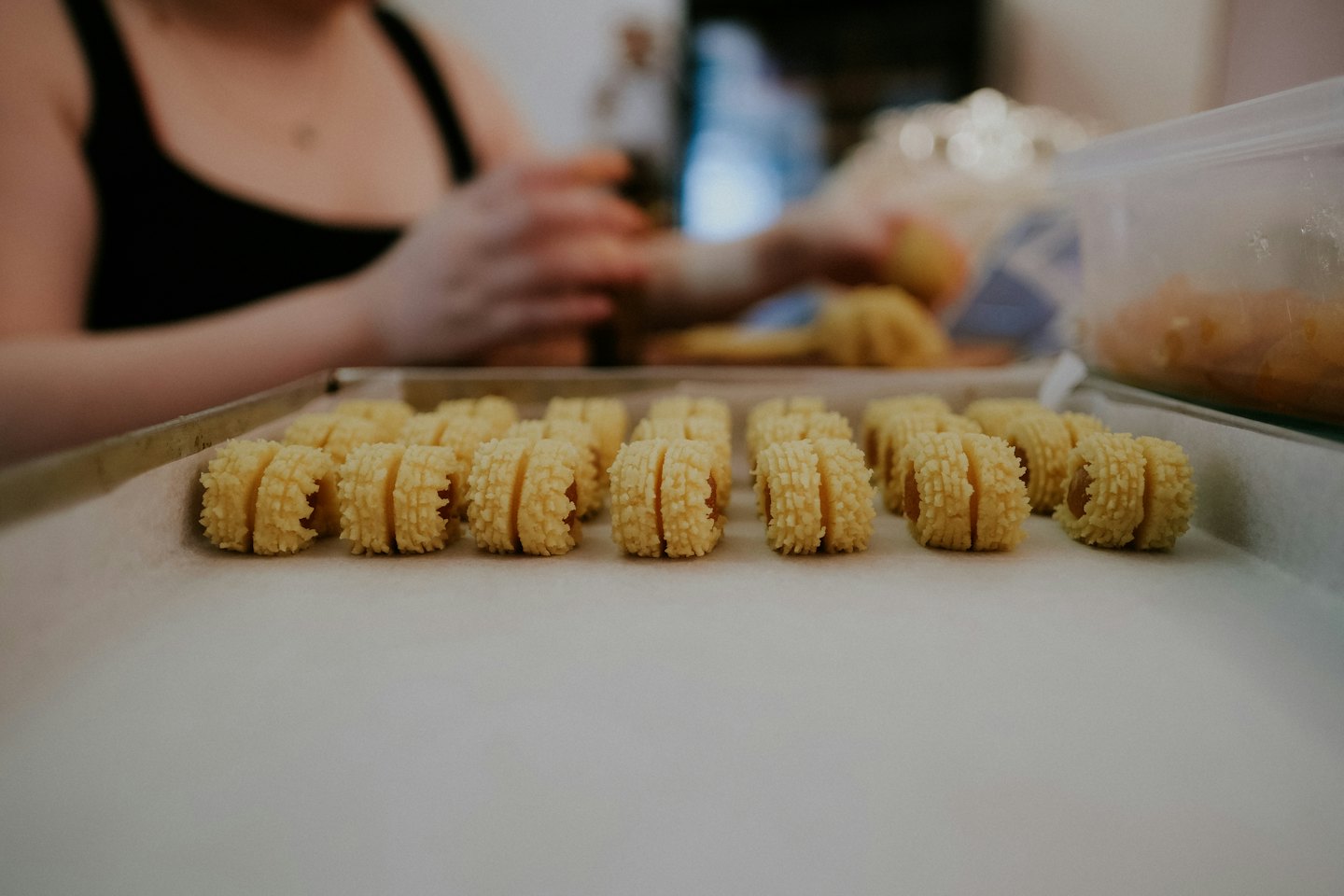 Rows of golden cylindrical cookies rest on a baking sheet.